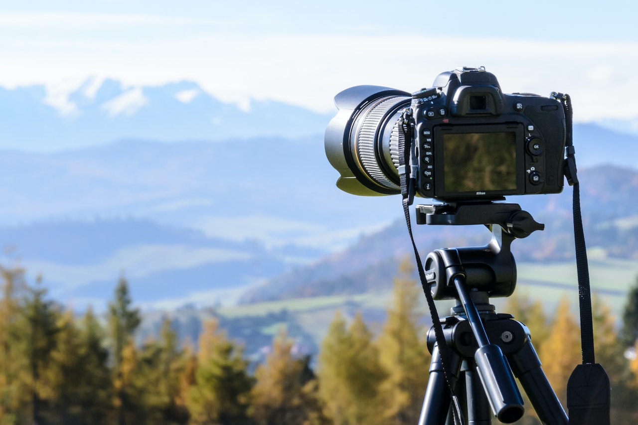 Black DSLR camera mounted on black tripod