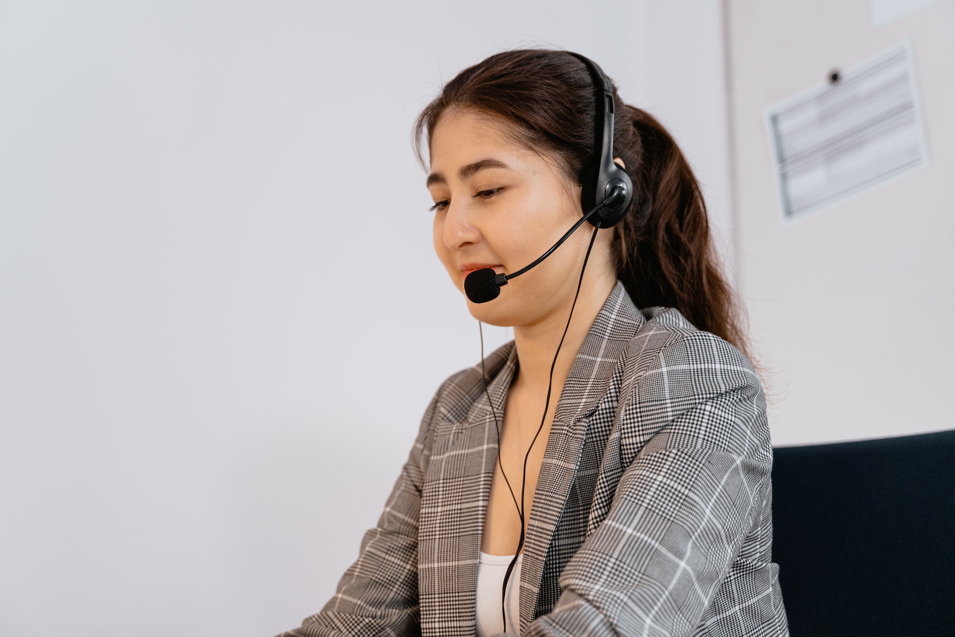 Woman in a blazer with a headset and microphone